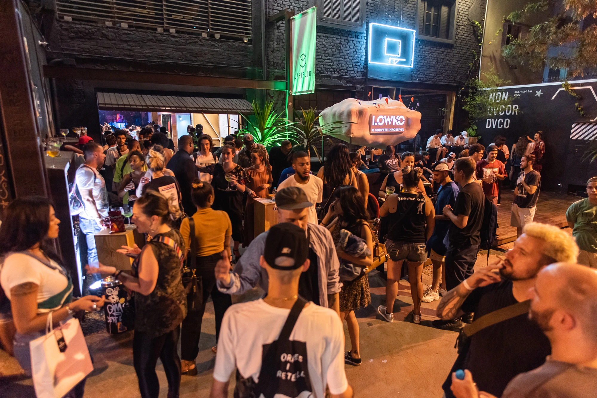 Crowds at the collection launch outside Cartel 011 in São Paulo at night.