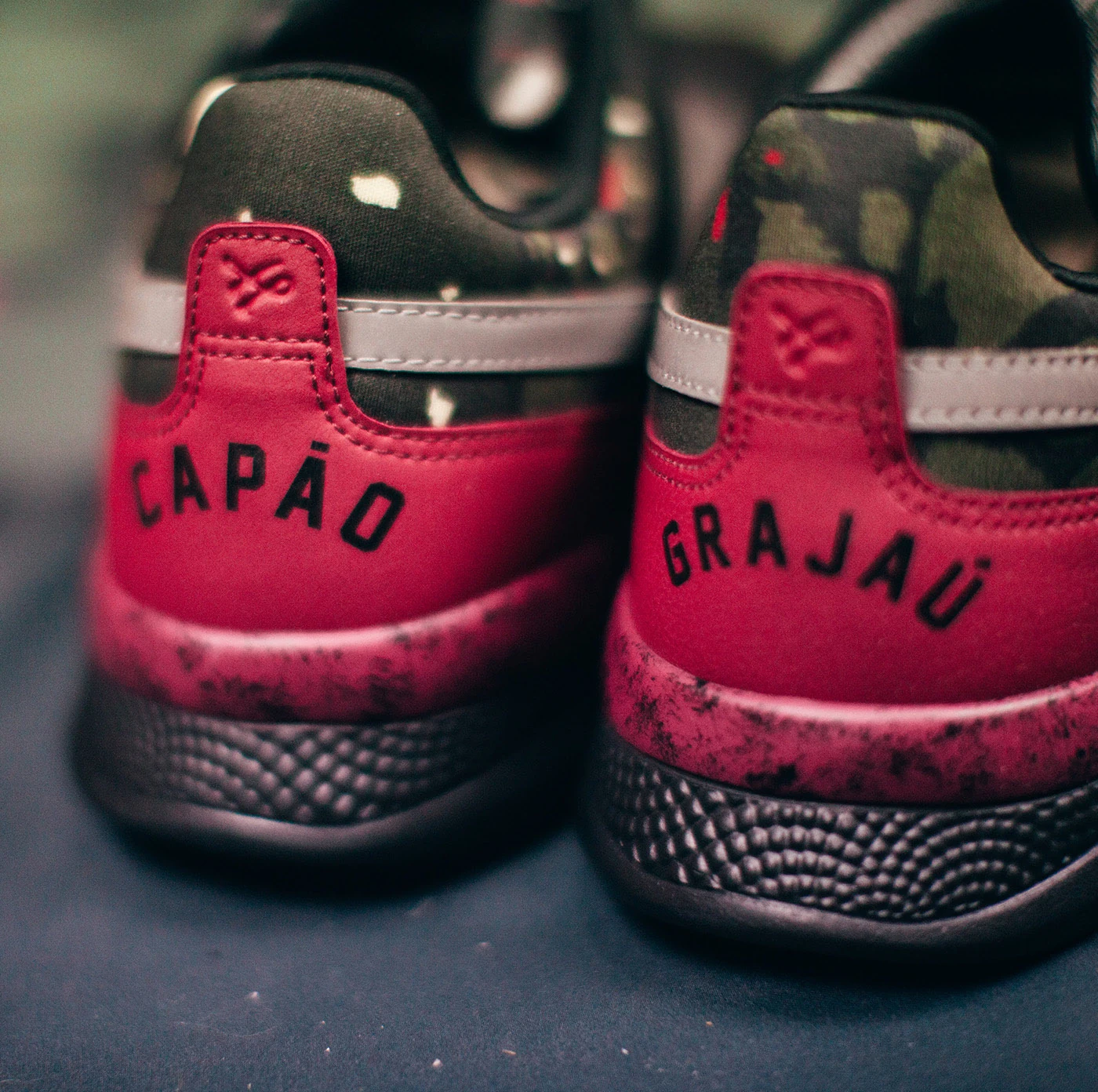 Detail of two sneaker heels embossed “CAPÃO” and “GRAJAÚ”.