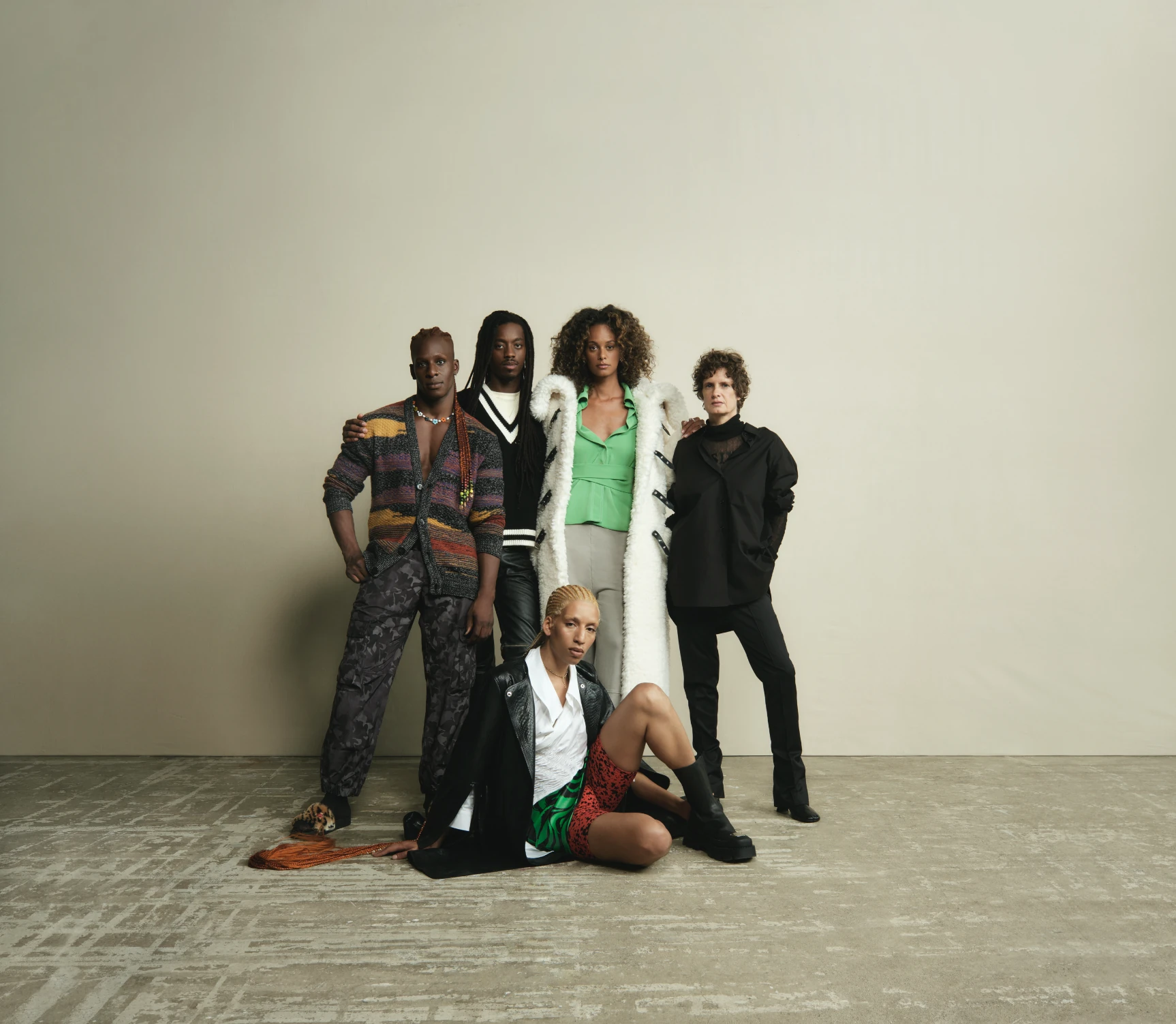 Five models grouped together against a studio backdrop.